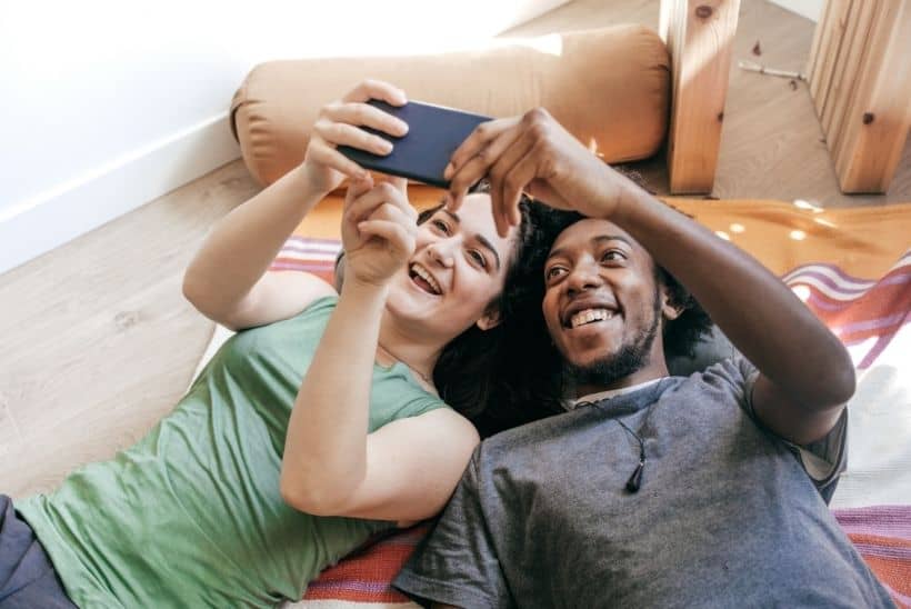 woman and man laying on floor watching videos