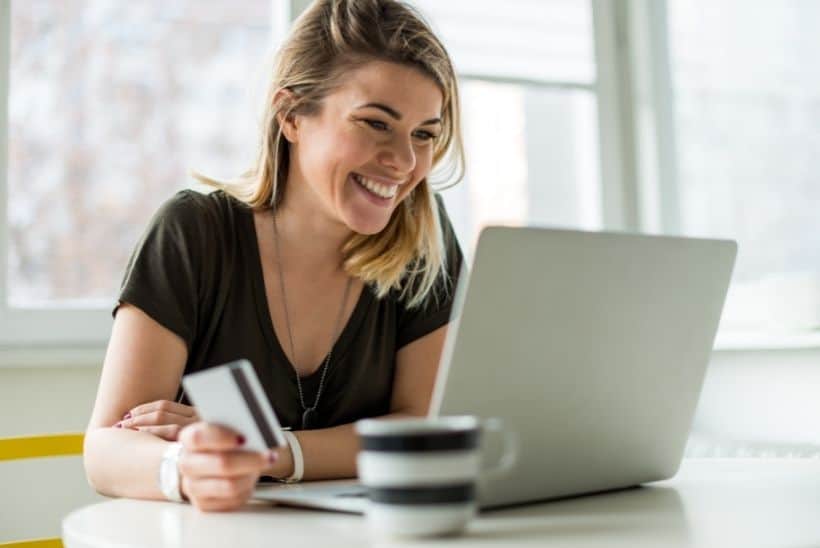 woman smiling with credit card in hand