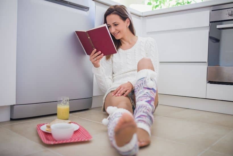 woman reading book on floor