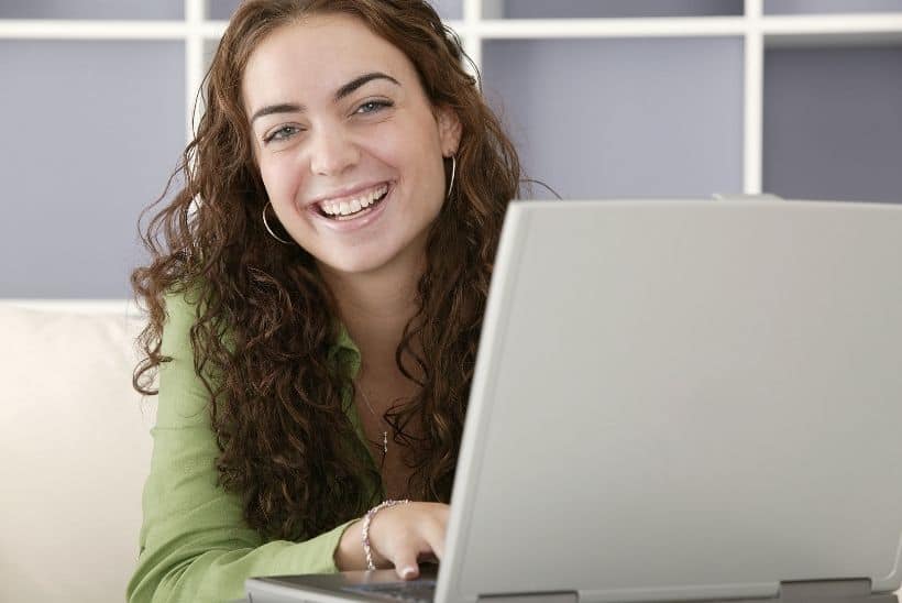 woman smiling while using laptop