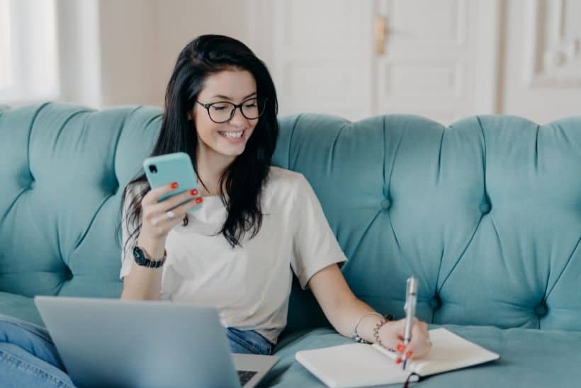 smiling woman writing in book 