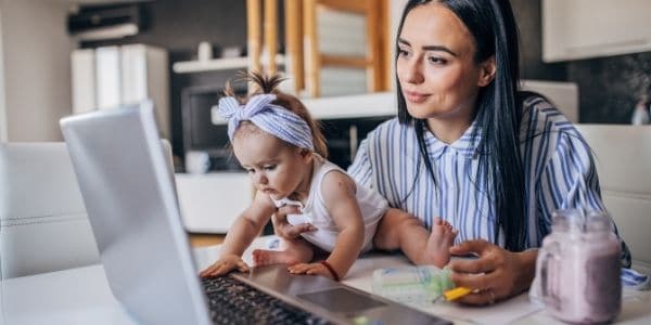 mom holding baby in lap while working