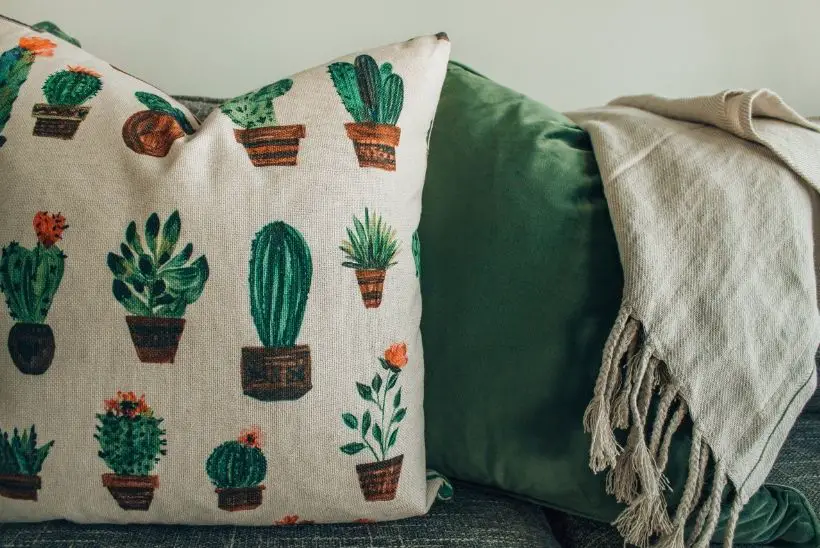 white throw pillow with cactus print