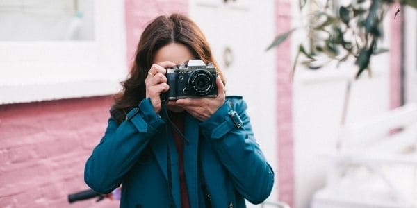 woman in green coat holding camera